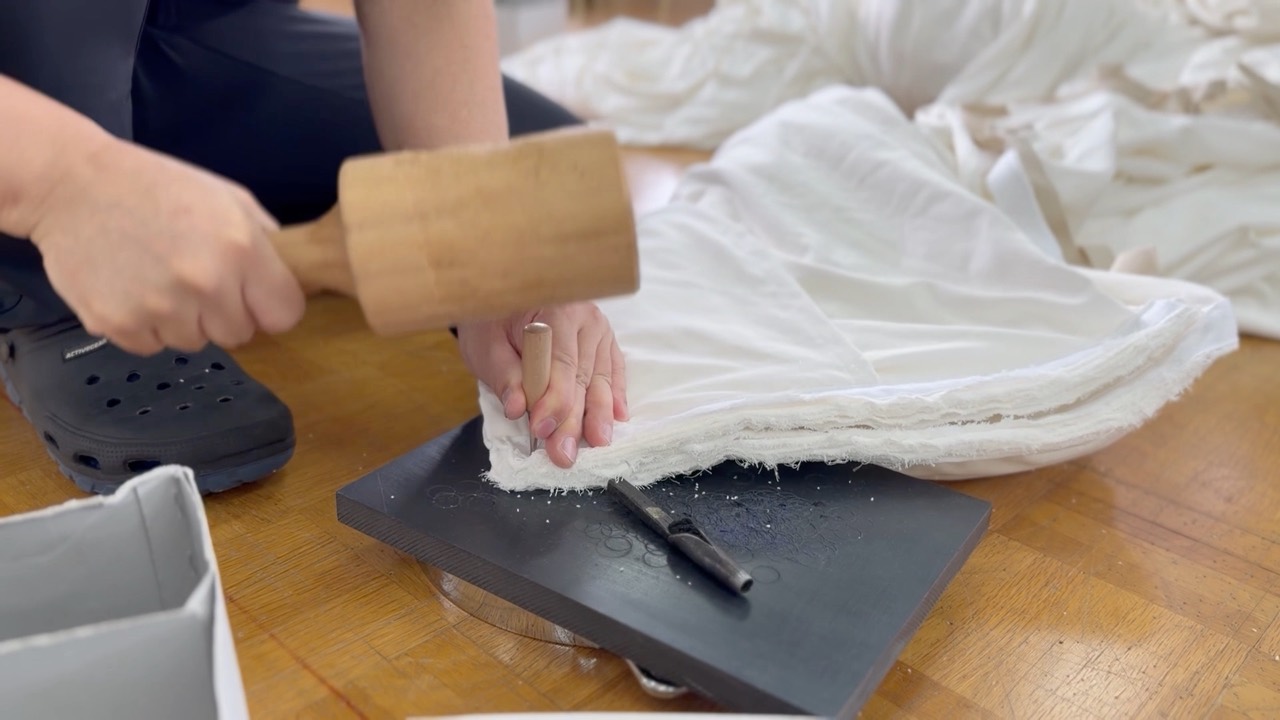 幕生地へ金具を取り付ける制作作業の様子
